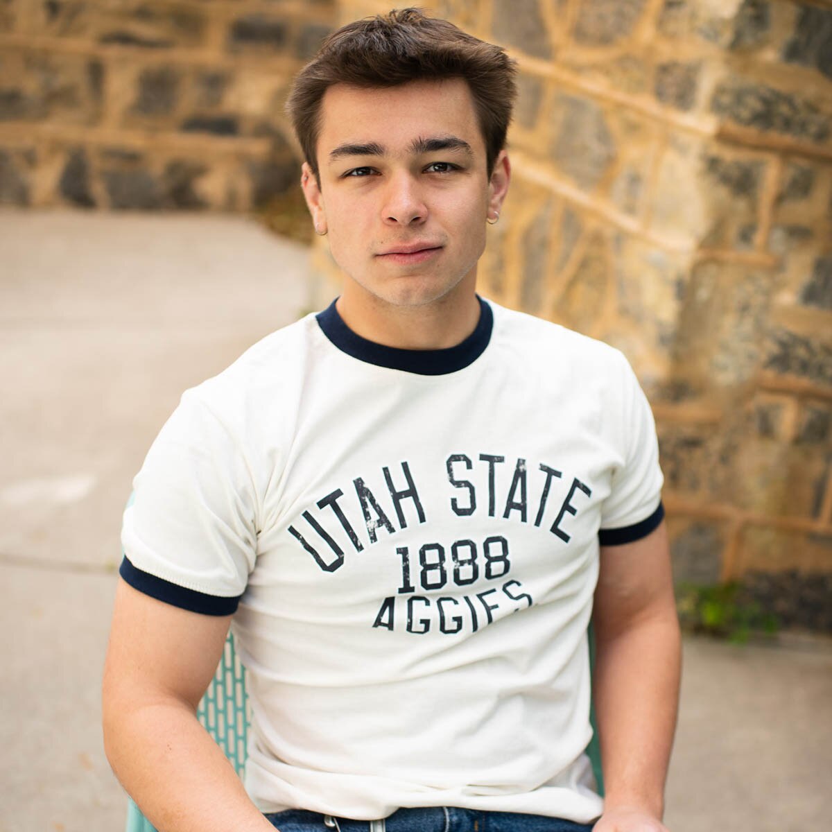 young man wearing cream and black utah state aggies ringer t-shirt
